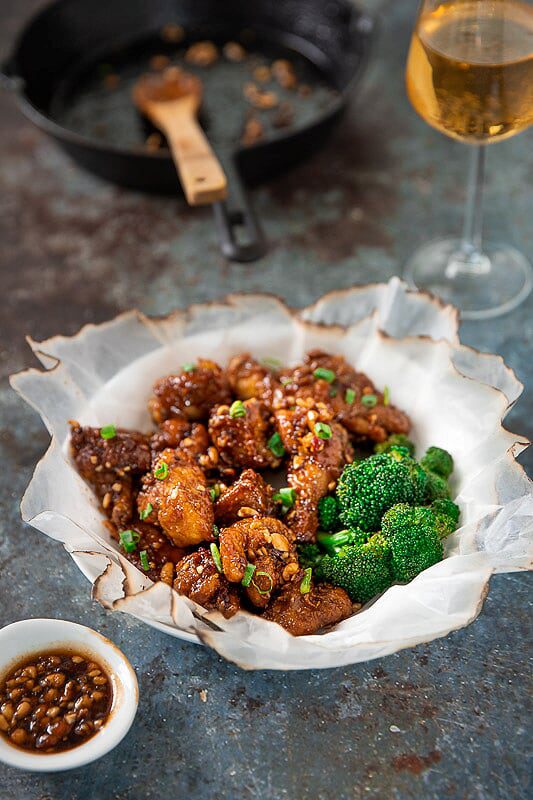 A bowl of Krisp Korean Fried Chicken served with Beer and Brocolli