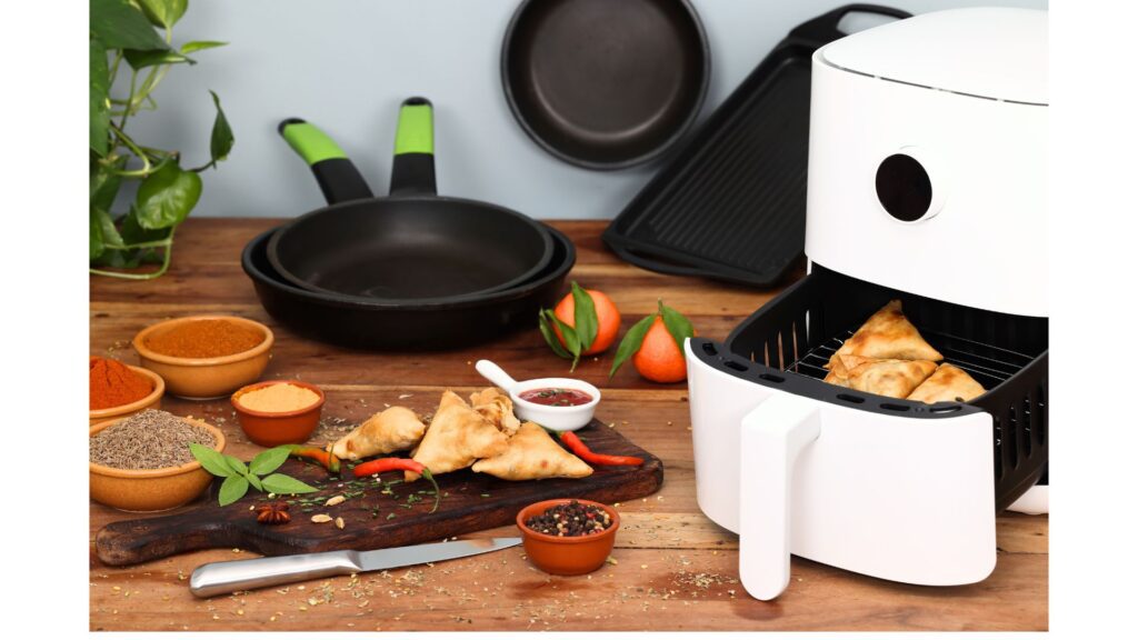 A white 4 quart air fryer on a countertop with samosas placed inside