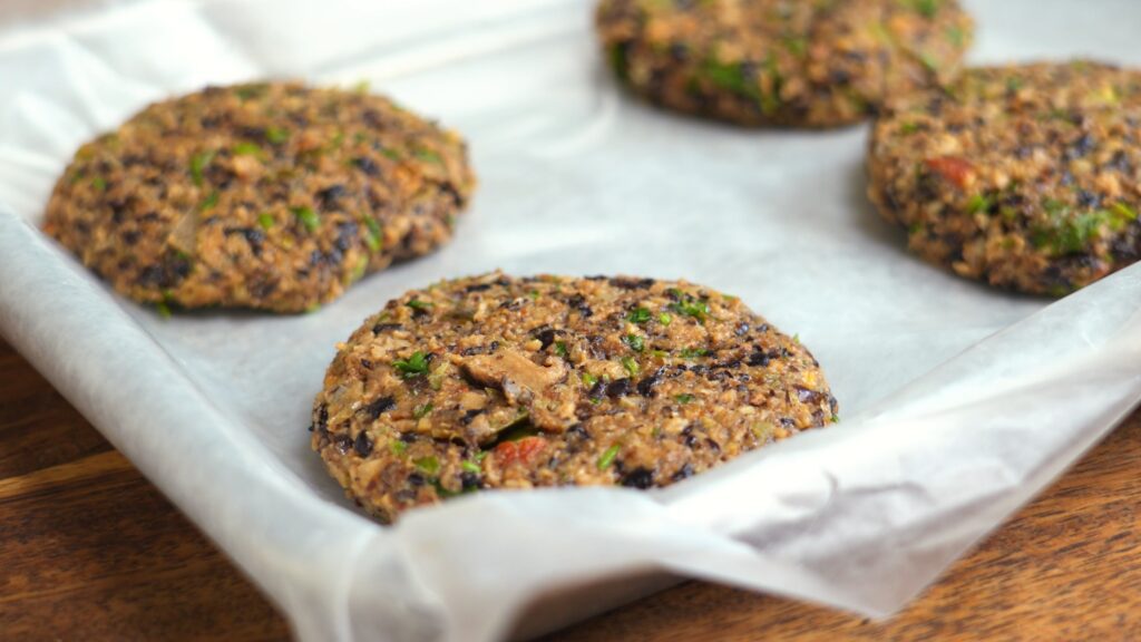 A tray of four black bean burger patties ready to be frozen