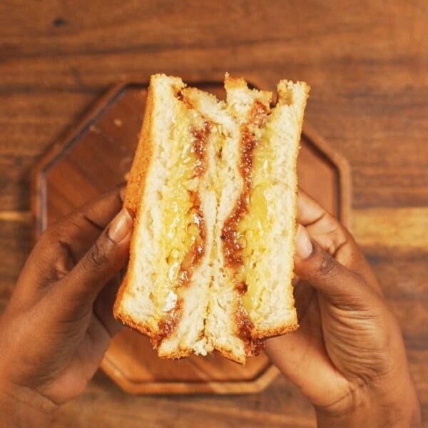 Air Fryer Grilled Cheese Sandwich Cut in Half and held in hand to show melted cheese