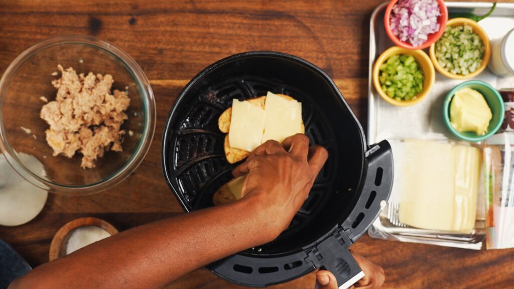 Overhead view of Chef Sam placing two breads with cheese into air fryer