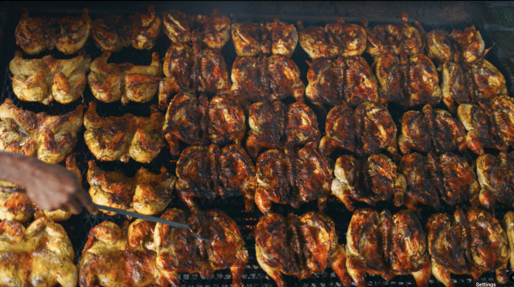 over 20 spatch cocked chickens, laying on a grill