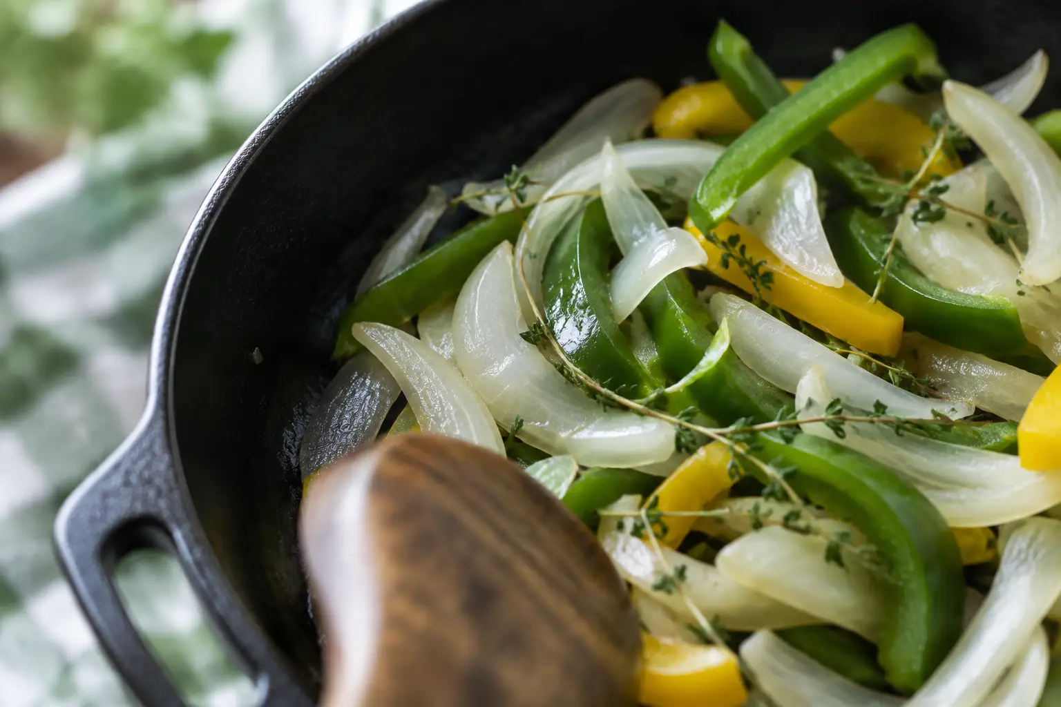 Soft translucent onion, sweet pepper, and thyme in a skillet without browning